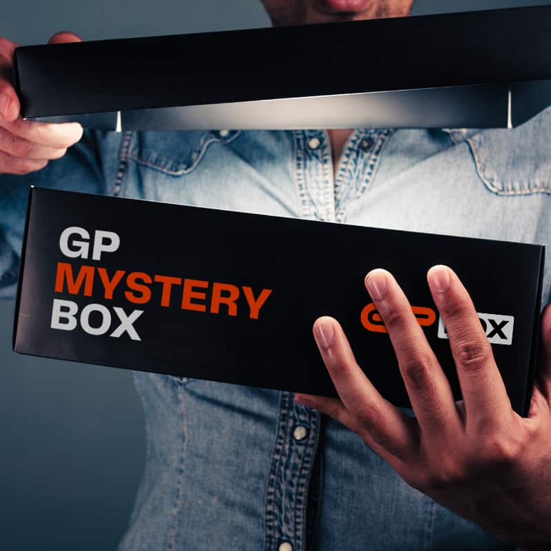 A picture of f1 themed mystery crate box subscriber opening the GP Mystery box and seeing good quality formula 1 fan products